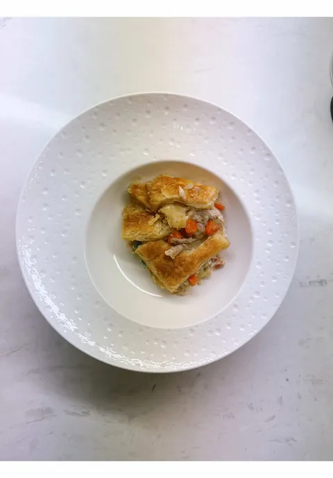 Individual chicken pot pie pieces with flaky golden crust and carrot filling