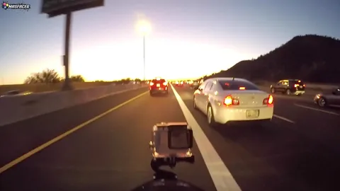 Riding in traffic filmed from motorcycle perspective on the street