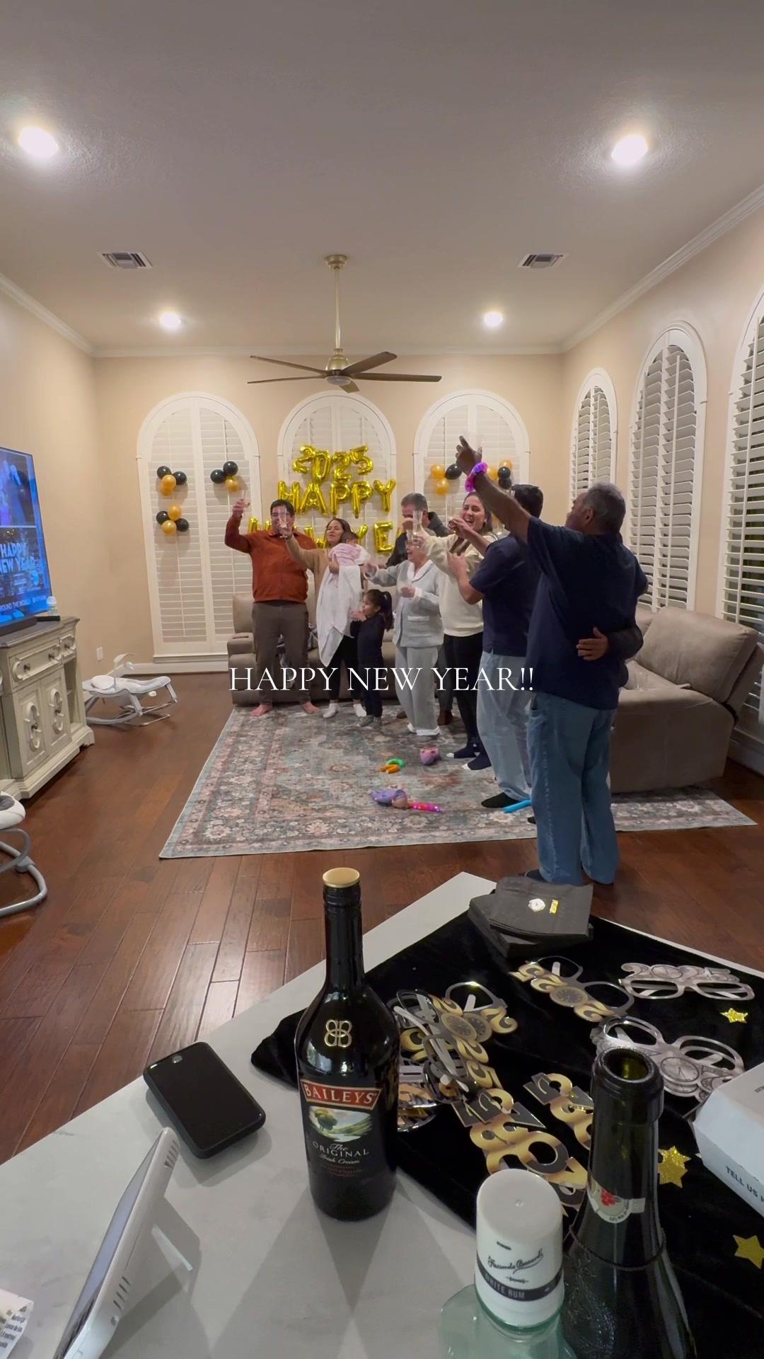 Family celebrating happy new year toasts and balloons for home cooking