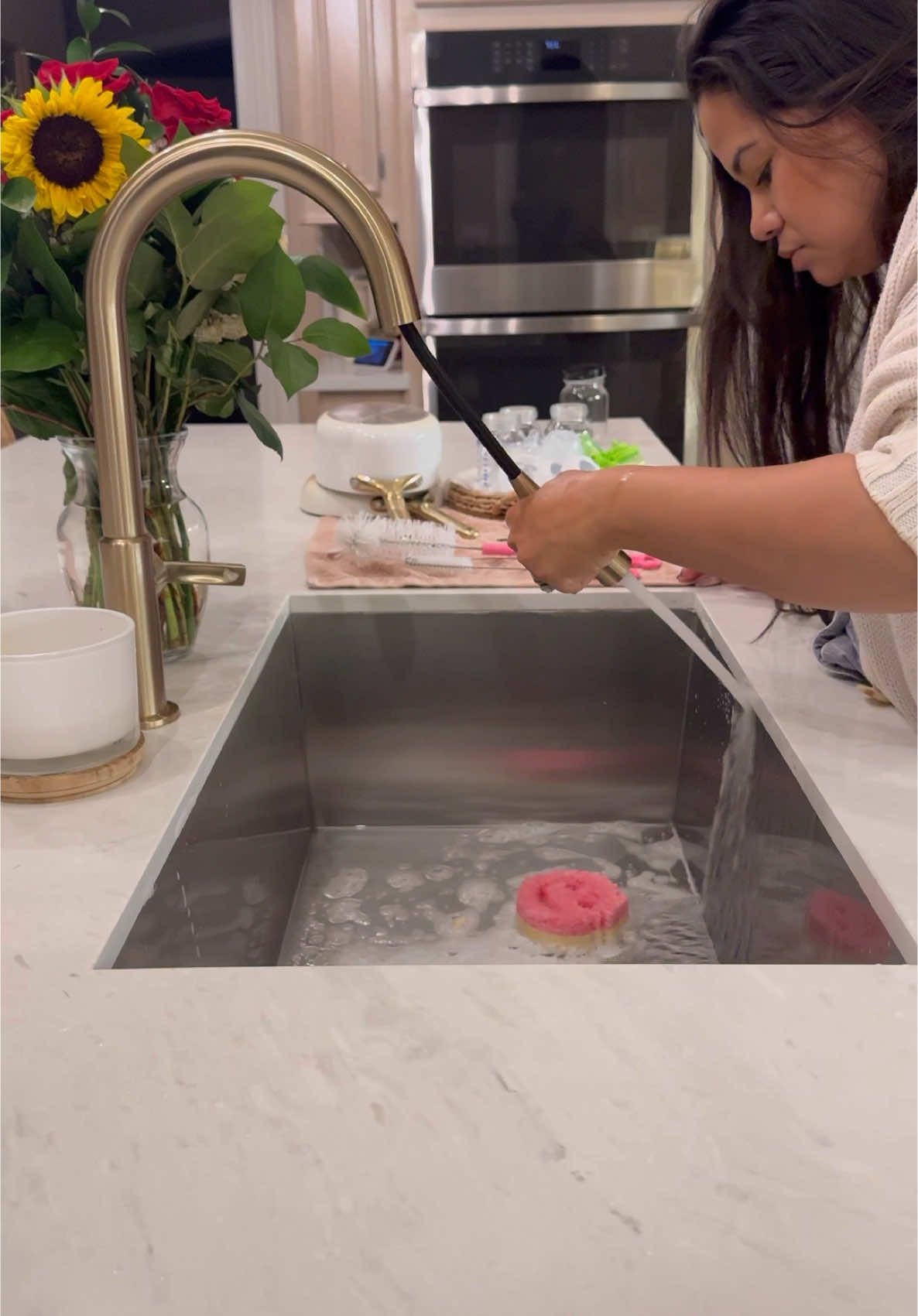 Mom starting baby millie evening routine cleaning bottles in kitchen sink