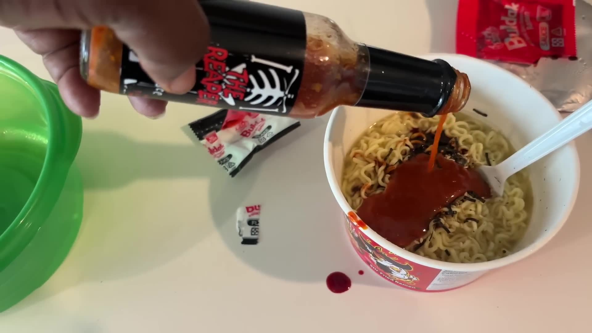 Adding extreme hot sauce to already dangerously spicy noodles