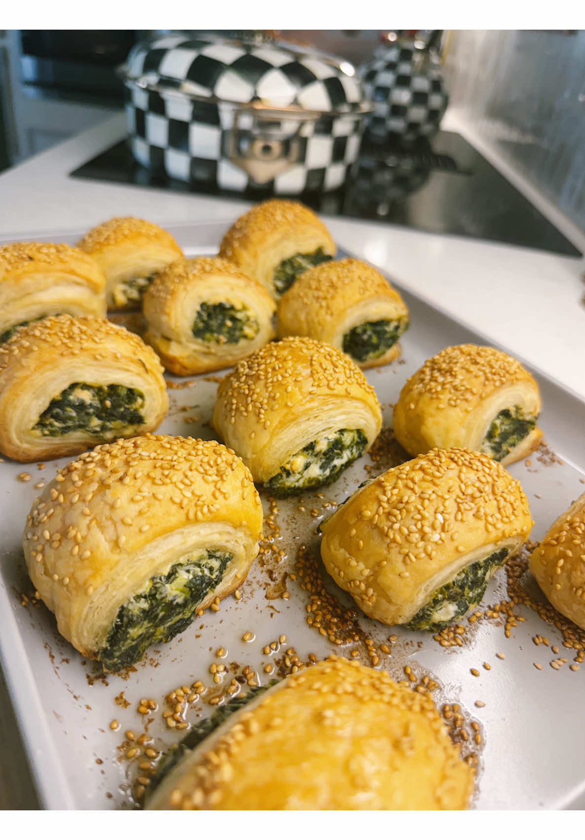 Homemade baked golden spinach and feta puff pastry rolls with sesame seeds