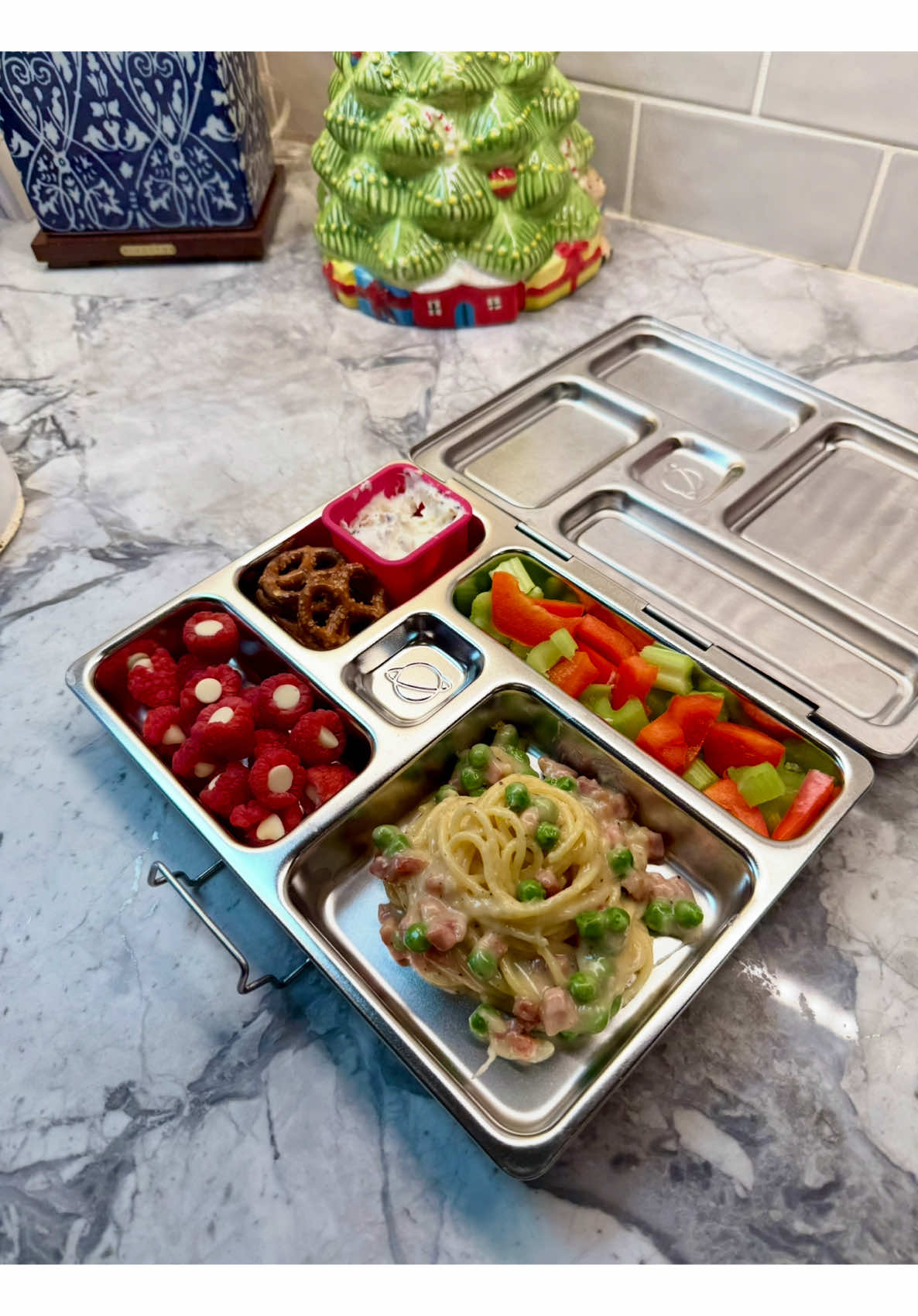 Creamy pasta lunch featuring ham, sweet peas, and berry accompaniment