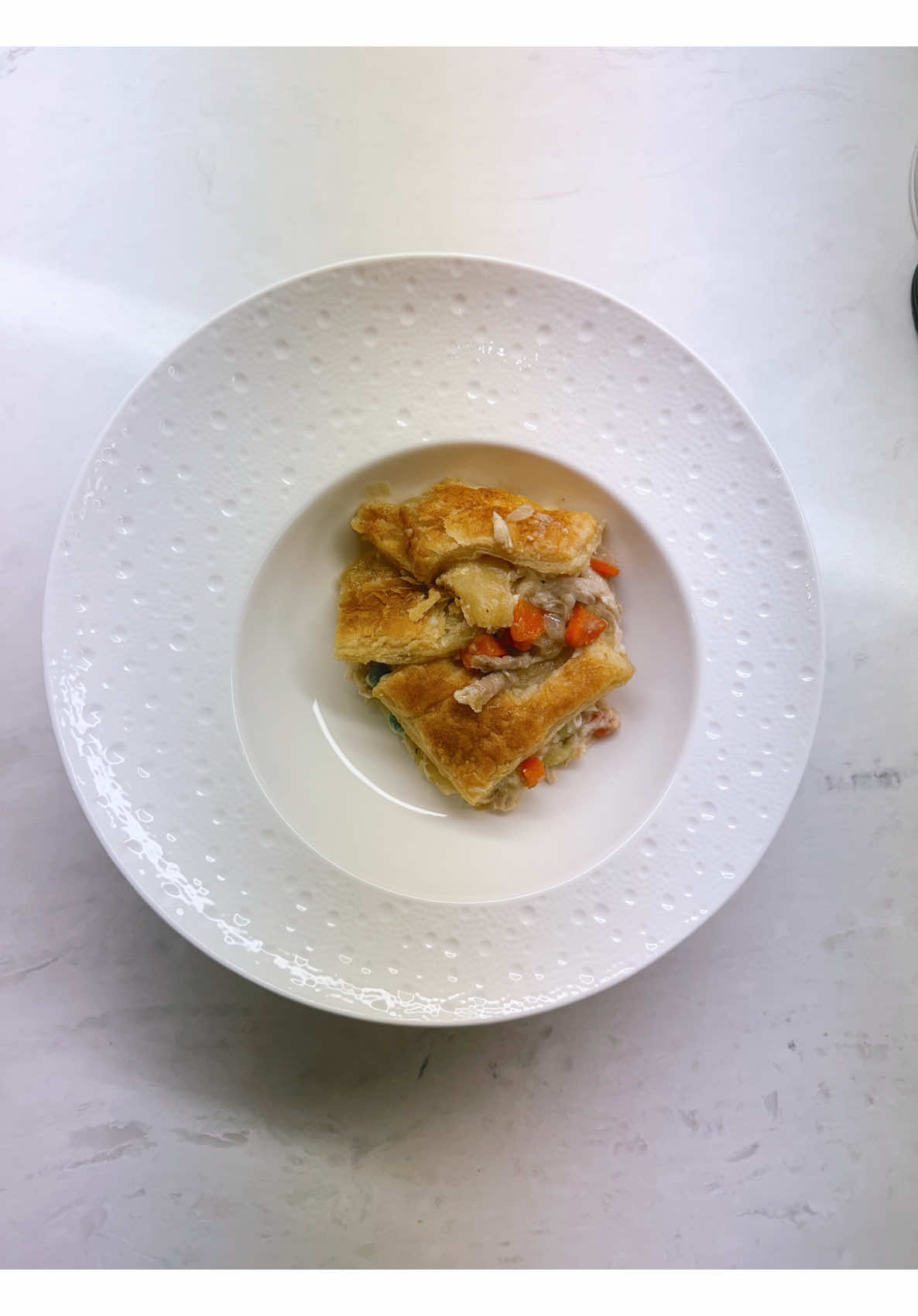 Individual chicken pot pie pieces with flaky golden crust and carrot filling